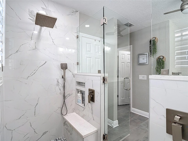 bathroom with a marble finish shower, ceiling fan, marble finish floor, and a textured ceiling