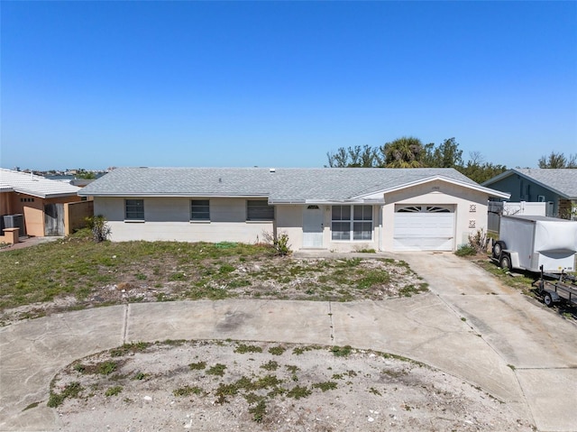 ranch-style home with driveway, an attached garage, and stucco siding