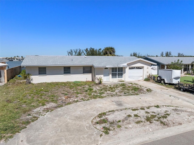ranch-style home with stucco siding, a garage, and concrete driveway