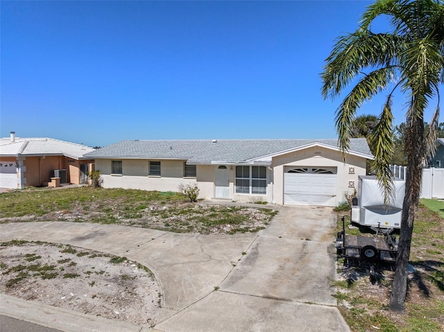 ranch-style house with stucco siding, an attached garage, fence, and concrete driveway