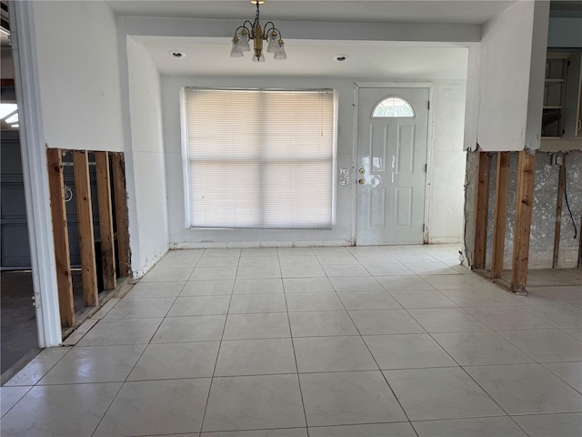 tiled foyer entrance with a wealth of natural light and a notable chandelier