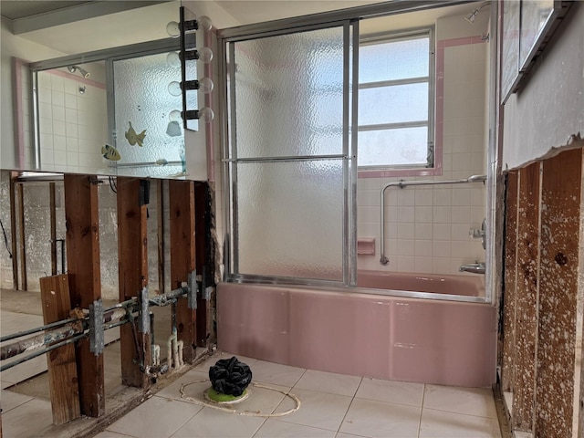 full bathroom featuring tile patterned floors and bath / shower combo with glass door