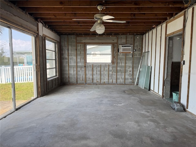 interior space with a wall mounted air conditioner and ceiling fan