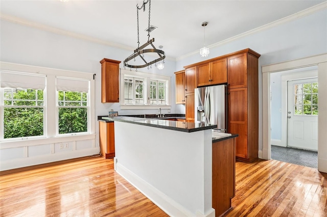 515 Frank Lloyd Wright Way, Lakeland, FL 33803 - kitchen with stainless steel refrigerator with ice dispenser, a sink, brown cabinets, light wood-type flooring, and dark countertops
