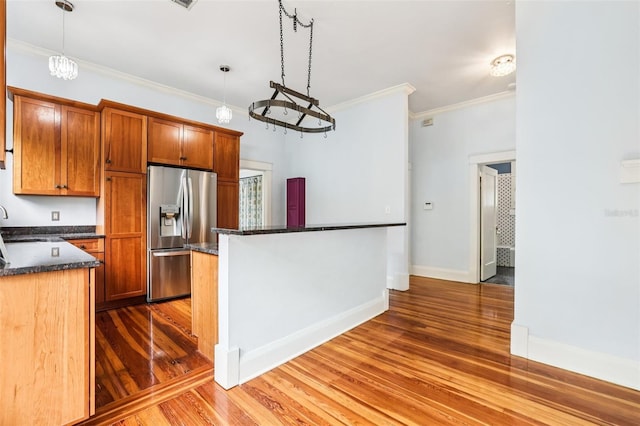 515 Frank Lloyd Wright Way, Lakeland, FL 33803 - kitchen with stainless steel fridge with ice dispenser, wood finished floors, crown molding, pendant lighting, and baseboards