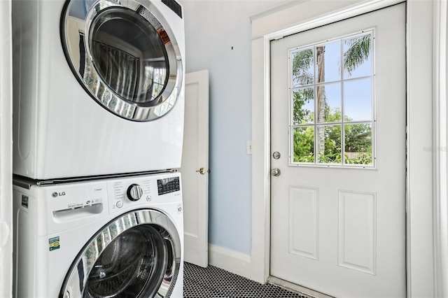 515 Frank Lloyd Wright Way, Lakeland, FL 33803 - laundry area featuring stacked washer / dryer, tile patterned floors, and baseboards