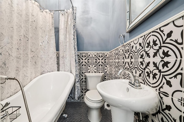 515 Frank Lloyd Wright Way, Lakeland, FL 33803 - bathroom featuring a freestanding tub, toilet, a sink, and tile patterned floors