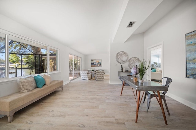 interior space featuring baseboards, visible vents, wood finished floors, and lofted ceiling