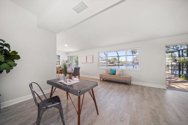 office area with a wealth of natural light, visible vents, light wood-style flooring, and baseboards