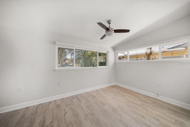 empty room with a ceiling fan, baseboards, vaulted ceiling, and wood finished floors