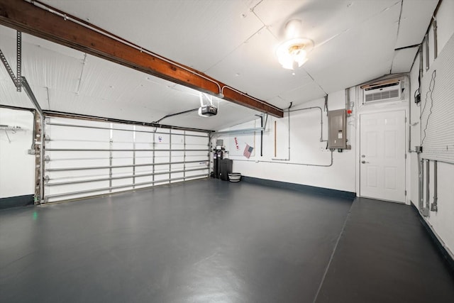 garage featuring electric panel, a garage door opener, a wall mounted air conditioner, and baseboards