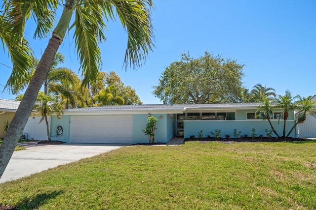 view of front of home with driveway, stucco siding, a front yard, and an attached garage