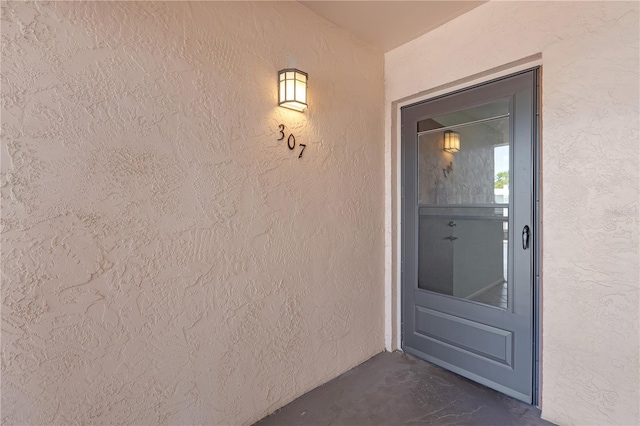 entrance to property featuring stucco siding