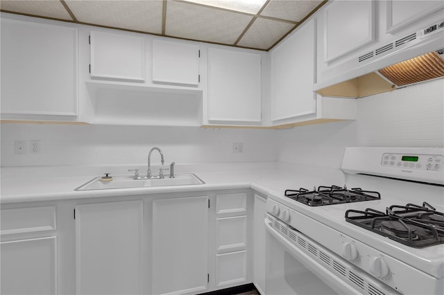 kitchen featuring a sink, under cabinet range hood, gas range gas stove, white cabinetry, and light countertops