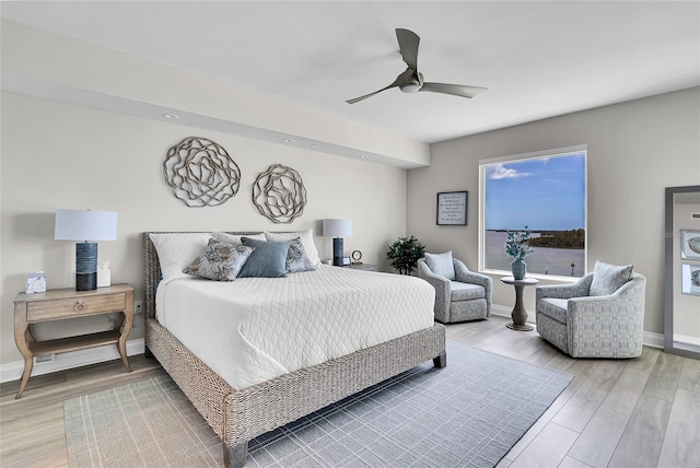 bedroom with light wood-style flooring, baseboards, and ceiling fan