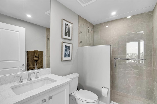 bathroom featuring recessed lighting, visible vents, toilet, vanity, and tiled shower