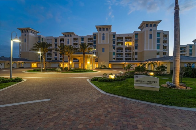 surrounding community featuring a lawn and uncovered parking