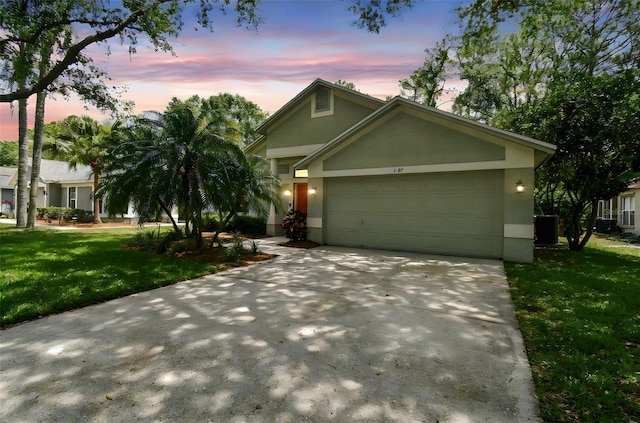 1187 Mistwood Dr, Tarpon Springs, FL 34688 - view of front of property with central AC unit, a front lawn, driveway, an attached garage, and stucco siding