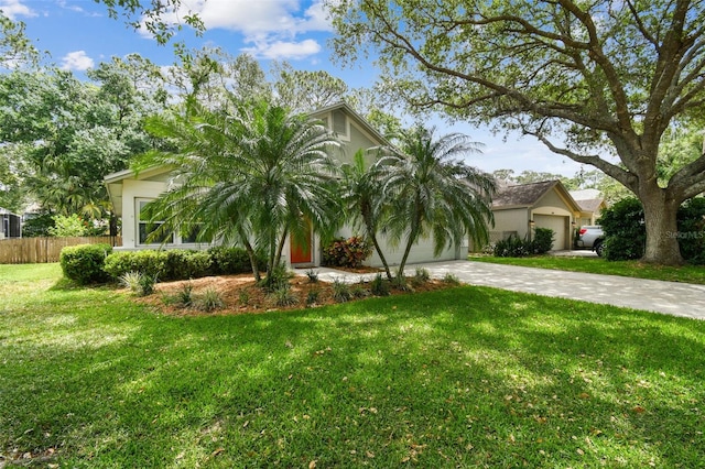 1187 Mistwood Dr, Tarpon Springs, FL 34688 - view of front of property with a front lawn, driveway, fence, a garage, and stucco siding