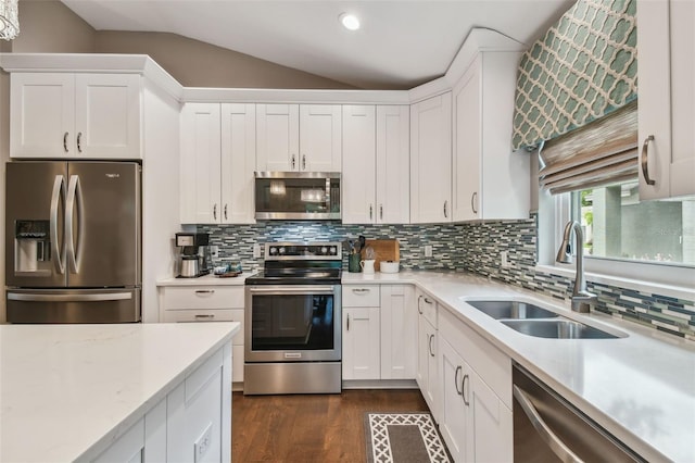 1187 Mistwood Dr, Tarpon Springs, FL 34688 - kitchen featuring dark wood finished floors, lofted ceiling, stainless steel appliances, a sink, and white cabinetry