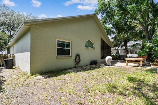 1187 Mistwood Dr, Tarpon Springs, FL 34688 - rear view of house with stucco siding, fence, a patio area, and a sunroom