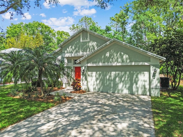 1187 Mistwood Dr, Tarpon Springs, FL 34688 - view of front of house with cooling unit, an attached garage, driveway, and stucco siding