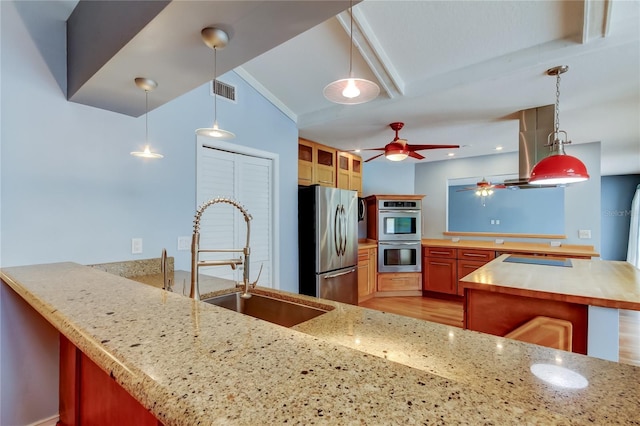 kitchen with a sink, visible vents, a peninsula, appliances with stainless steel finishes, and ceiling fan