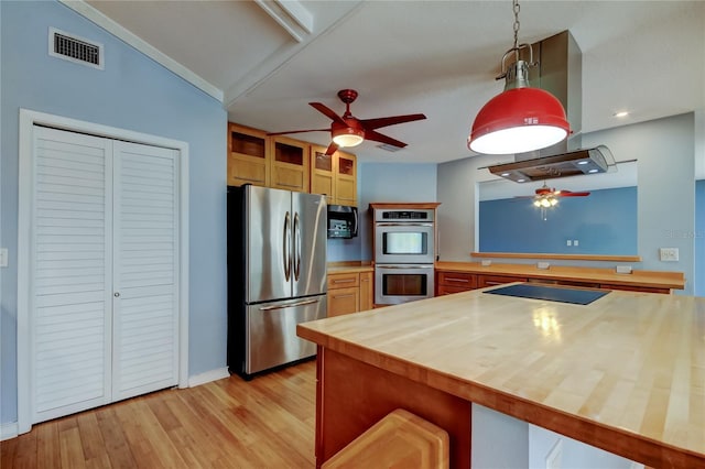 kitchen with butcher block counters, visible vents, a ceiling fan, a peninsula, and appliances with stainless steel finishes