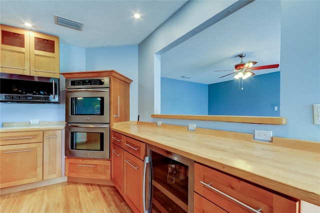kitchen with butcher block counters, wine cooler, visible vents, a ceiling fan, and appliances with stainless steel finishes
