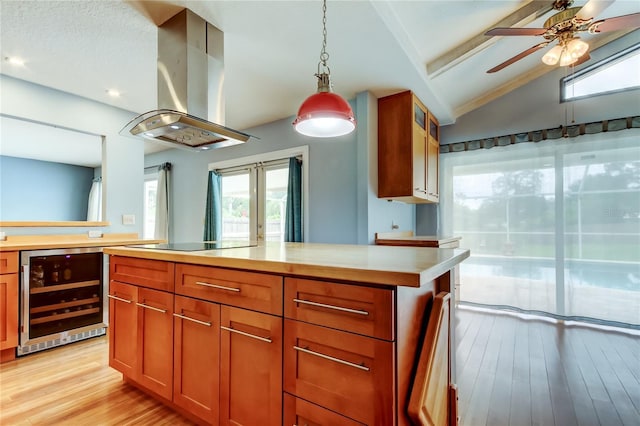 kitchen featuring light countertops, vaulted ceiling with beams, black electric stovetop, beverage cooler, and extractor fan
