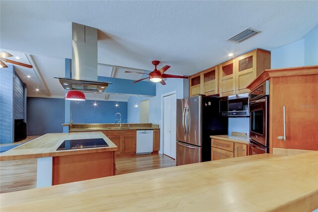 kitchen with island range hood, visible vents, appliances with stainless steel finishes, and a ceiling fan