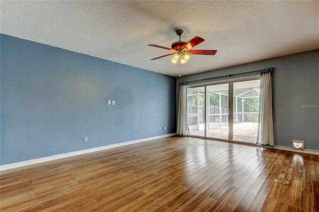 unfurnished room featuring baseboards, a textured ceiling, ceiling fan, and wood finished floors
