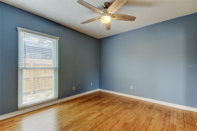 spare room with baseboards, ceiling fan, and wood finished floors
