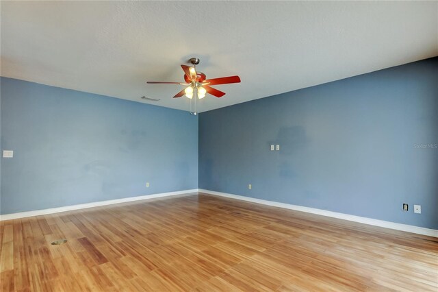 unfurnished room with baseboards, visible vents, a ceiling fan, and light wood finished floors