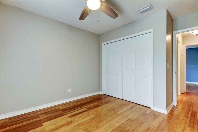 unfurnished bedroom with baseboards, visible vents, a closet, and light wood-style flooring