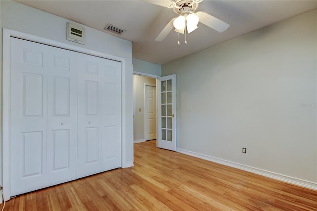 unfurnished bedroom featuring a closet, visible vents, light wood finished floors, baseboards, and a ceiling fan