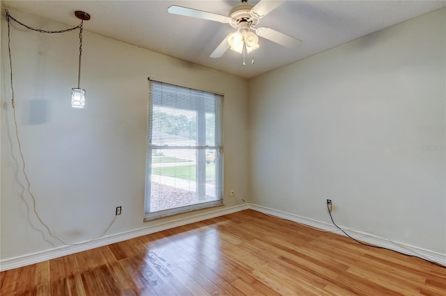 empty room with baseboards, ceiling fan, and light wood-type flooring