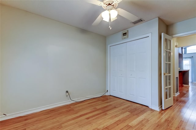 unfurnished bedroom featuring light wood-style flooring, baseboards, visible vents, a ceiling fan, and a closet