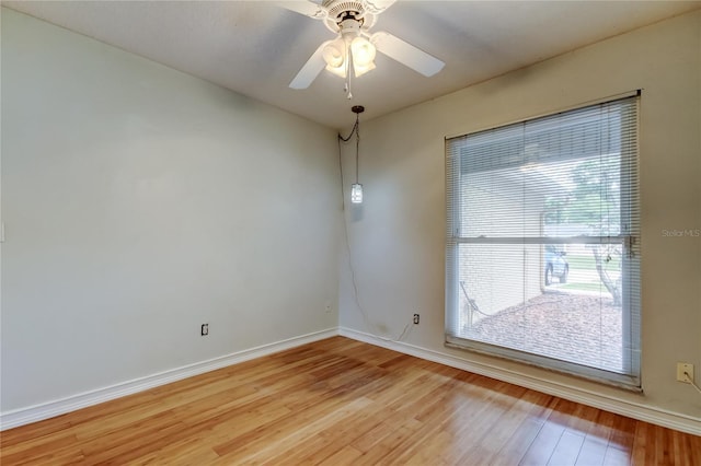 unfurnished room with a ceiling fan, baseboards, and light wood-style floors