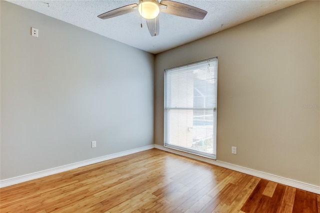 unfurnished room with baseboards, a textured ceiling, ceiling fan, and light wood-style floors