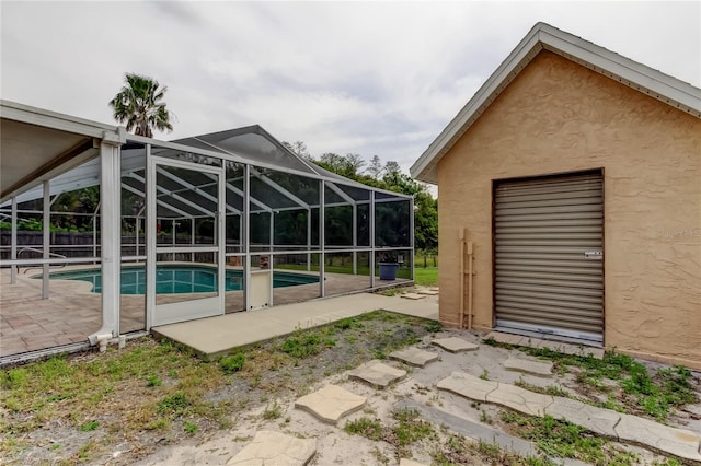outdoor pool featuring fence, a lanai, and a patio area