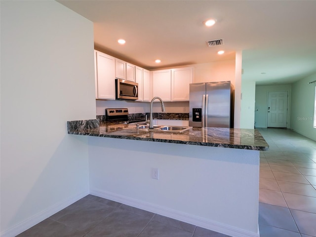 16805 Delia St, Wimauma, FL 33598 - kitchen featuring stainless steel appliances, visible vents, a sink, dark stone counters, and a peninsula