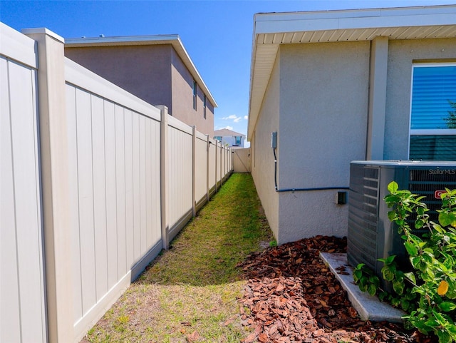 16805 Delia St, Wimauma, FL 33598 - view of home's exterior with stucco siding, central AC unit, and fence