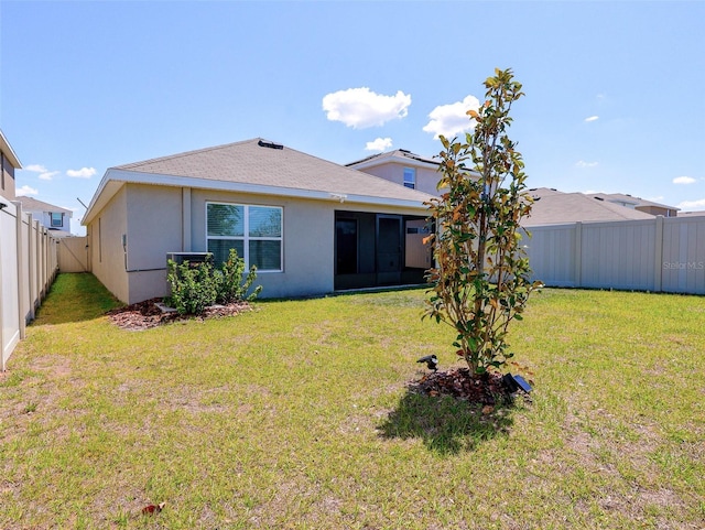 16805 Delia St, Wimauma, FL 33598 - back of property featuring a fenced backyard, a sunroom, a lawn, and stucco siding
