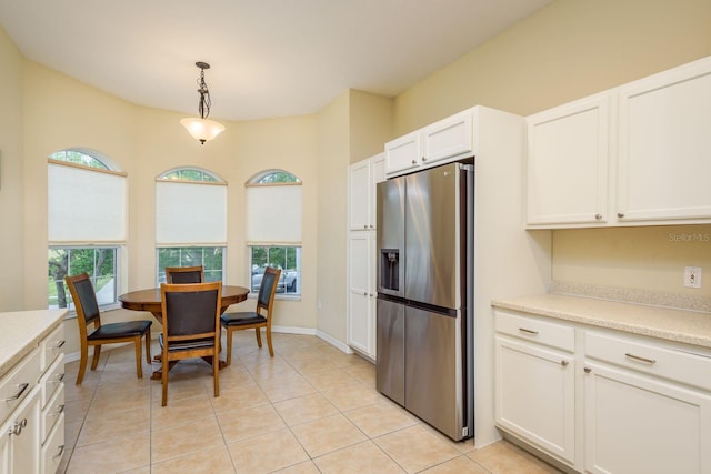 kitchen with white cabinets, pendant lighting, light countertops, and stainless steel fridge