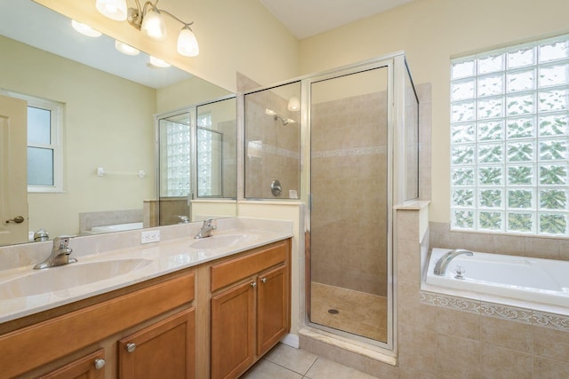 bathroom featuring a shower stall, double vanity, a sink, and tile patterned flooring