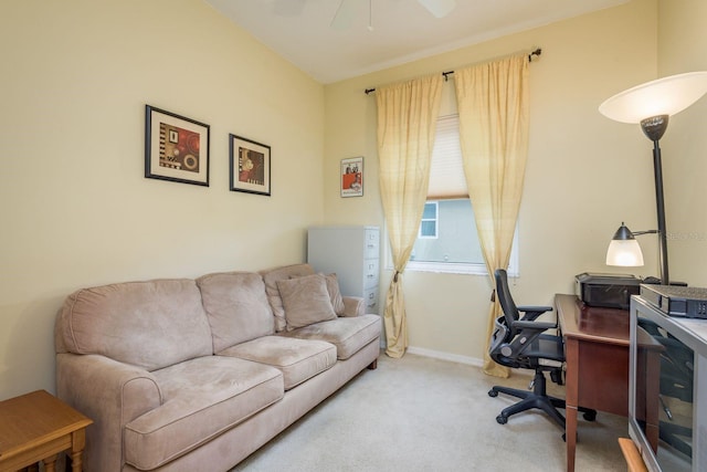 carpeted office space with ceiling fan and baseboards