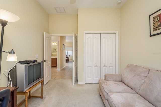 sitting room with light tile patterned floors, visible vents, light colored carpet, and baseboards