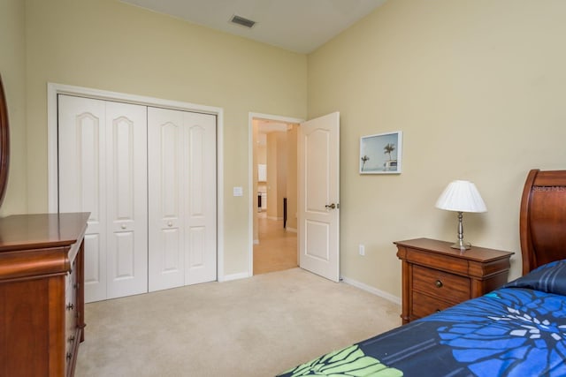 carpeted bedroom with visible vents, a closet, and baseboards