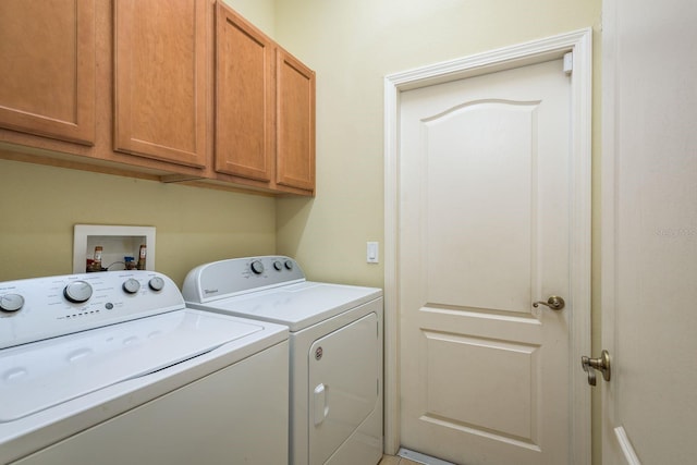 clothes washing area featuring cabinet space and washer and clothes dryer